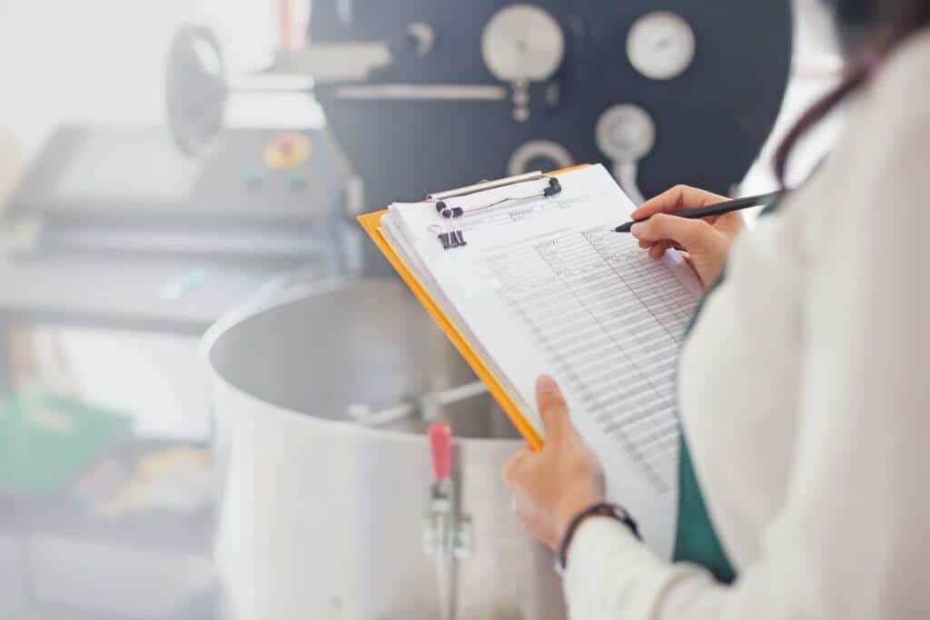 food manufacturing worker taking notes